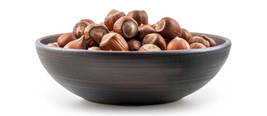 Fototapeta premium Whole Ripe Brown Hazelnuts in Dark Bowl Isolated on White Background