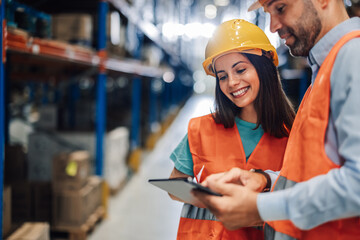 Warehouse workers using digital tablet checking inventory in logistics center