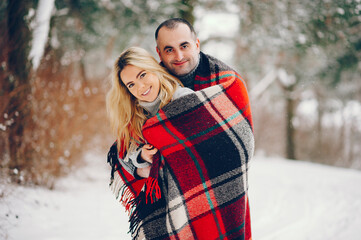 Beutiful woman in a winter park with her husband