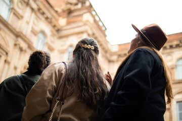 3 amies de dos regardant un hôtel
