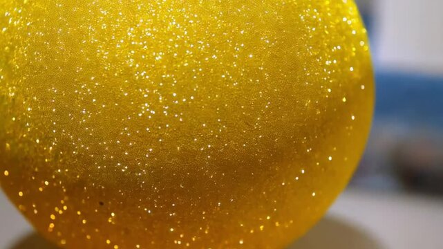 A vibrant yellow sphere with glimmers, adding a cheerful element to the composition.
