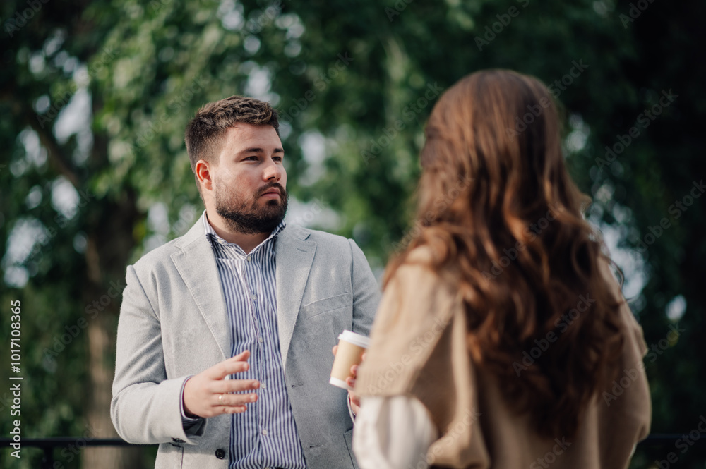 Wall mural businessman explaining something to his female colleague outdoors