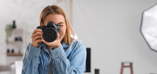 Female photographer with professional camera in studio