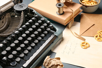 Composition with vintage typewriter, letter, envelope, crumpled paper and snacks on grey background