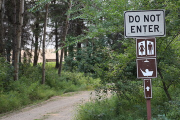 confusing sign beside rural gravel road in trees