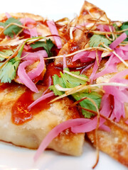 Rabioles con salsa roja y verduras.