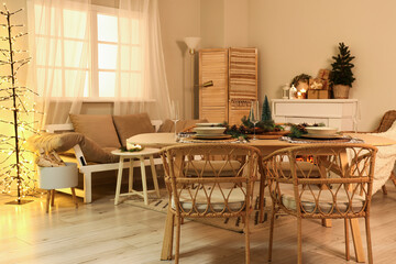 Interior of cozy living room with Christmas table setting at evening