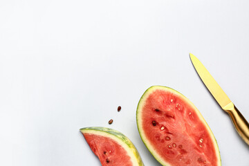 Pieces of fresh watermelon and seeds on grey background