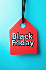 A red tag with the word Black Friday written on it. The tag is hanging from a blue background