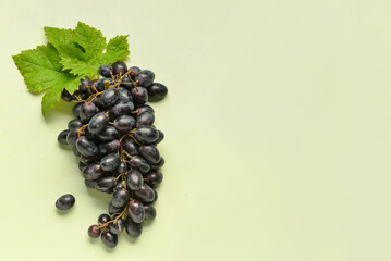 Sweet black grapes on green background