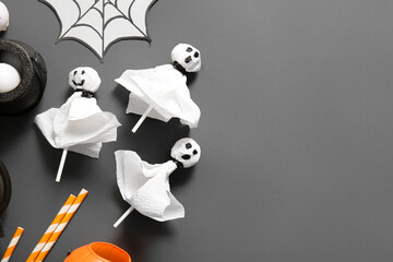 Sweet lollipops with paper cobweb and straws for Halloween party on black background