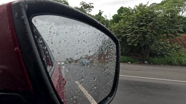 Vista de autopista a trav&eacute;s de retrovisor en un d&iacute;a lluvioso en la Panamericana en Panam&aacute;.