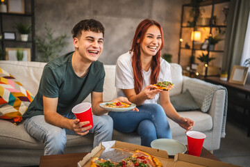 Adult couple boyfriend and girlfriend hanging out at home eat pizza