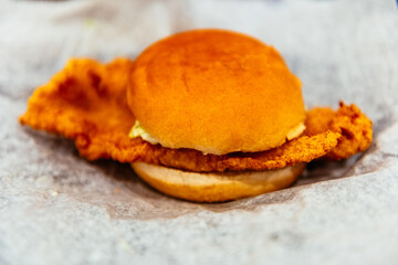 A fried fish fillet sandwich on white parchment paper