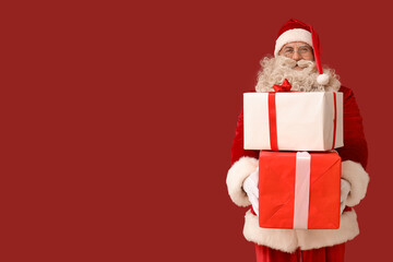 Santa Claus with Christmas gifts on red background