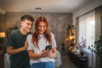 Beautiful young couple girlfriend and boyfriend use mobile at home