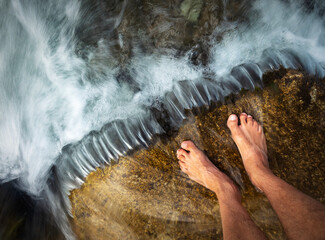 bare feet in a cold stream with rapids