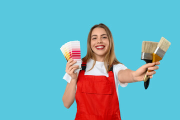 Female painter with color palettes and brushes on blue background