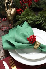 Christmas place setting with festive decor on wooden table, closeup