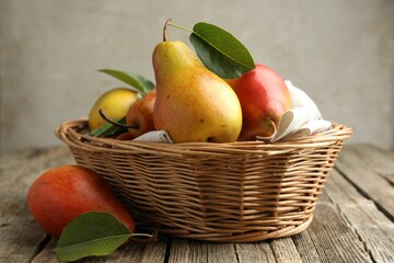 Ripe juicy pears in wicker basket on wooden table