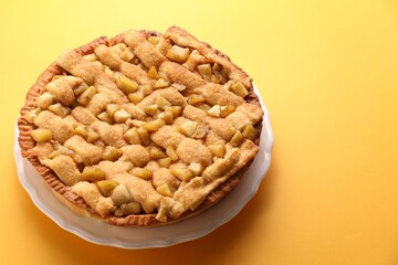 Tasty homemade apple pie on yellow background. Space for text
