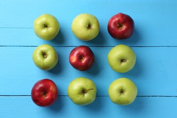 Fresh red and green apples on light blue wooden table, flat lay