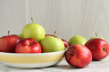 Ripe red and green apples on white marble table