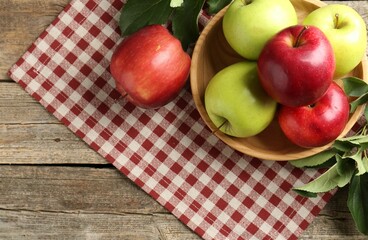 Ripe apples and green leaves on wooden table, top view