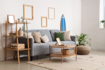 Modern comfortable interior of living room with soft sofa and table, blurred view