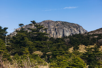 Hallasan National Park, Jeju island, South Korea, spring landscape view of Yeongsil trail, Halla volcano peak, trekking and climbing to Halla mountain, travel and hiking in Korea, Jeju-do, sunny day