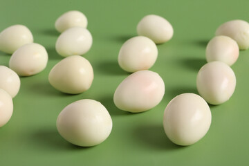 Fresh boiled quail eggs on green background