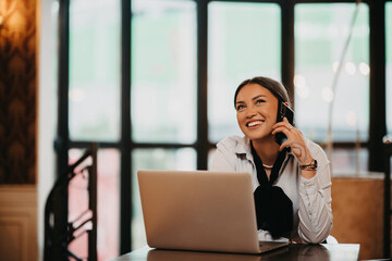 Latina businesswoman engaging with colleagues through her smartphone at a cozy coffee
