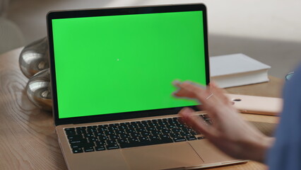 Student watching chromakey laptop webinar at home closeup. Unknown person hand