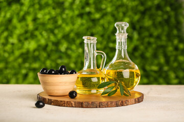 Decanters of fresh olive oil on white table outdoors