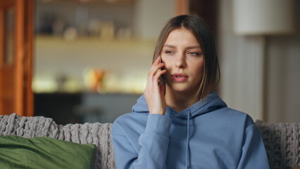 Woman have smartphone call in modern living room apartment closeup. Serious lady