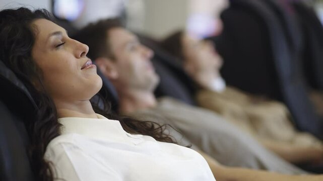 People enjoying derive pleasure while sitting in the massage chair at the shopping mall. Slow-motion