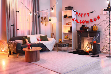 Interior of dark living room with grey sofa, fireplace and Halloween decorations