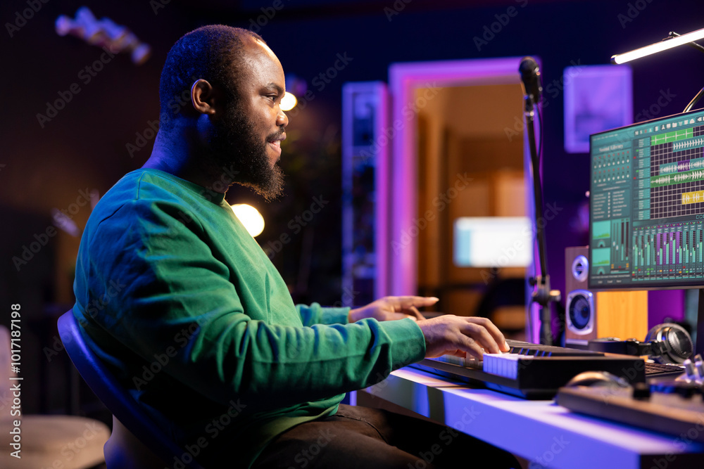Poster sound engineer pressing keys of electronic synthesizer and composing new song, adjusting volume leve