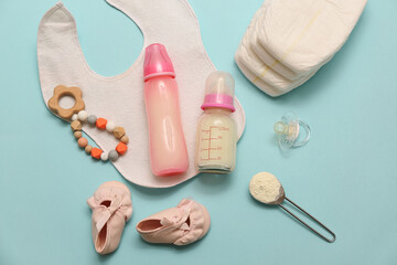 Bottles with baby milk formula and accessories on color background