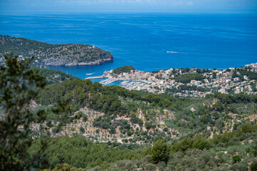 Port Soller Mallorca, view from the distance with the bay, cityscape, sea in the background, tree in front, majorca