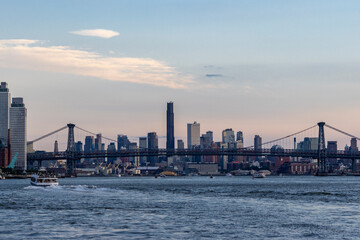 Obraz premium Golden hour illuminates the New York City skyline with silhouettes of Manhattan skyscrapers