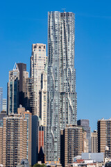 Obraz premium Modern architecture in New York City showcasing glass skyscrapers during a sunny afternoon with clear blue skies