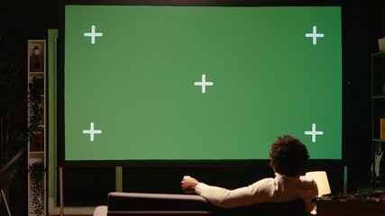 Man watching sports competition live on ultrawide mockup smart TV, cheering for favorite team. Cord cutter following subscription based sporting matches on isolated screen television set