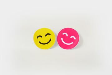 pink and yellow smiling emoticon card on white background with copy space