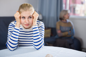 Elderly mother is unhappy with her adult daughter during a domestic quarrel