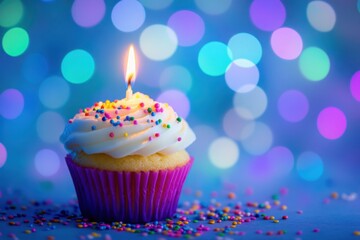 A colorful birthday cupcake with white frosting and sprinkles.
