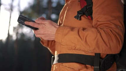 travel navigation. man tourist looking for a way in a smartphone navigation in winter in a forest park. male hacker navigates in the forest navigation close-up looking for a way in winter in park