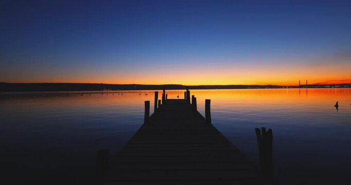 Scenic color sea sunset over wooden fishing pier and ripple water video