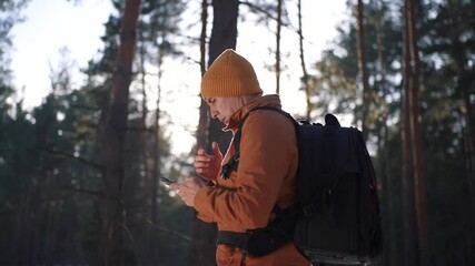 travel navigation. man tourist looking for a way in a smartphone navigation in winter in a forest park. male close-up hacker navigates in the forest navigation looking for a way in winter in park