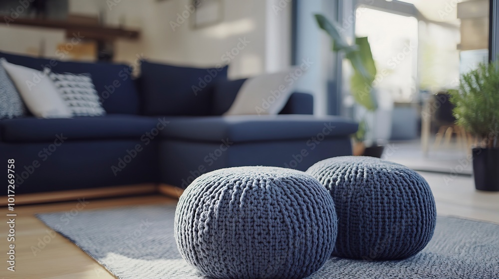 Poster Two knitted poufs near dark blue corner sofa. Scandinavian home interior design of modern living room  